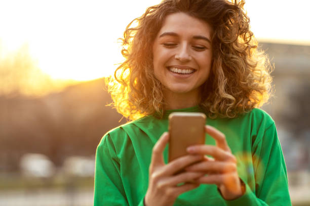 Woman using a smartphone outdoors, illustrating mobile internet usage in Dubai.