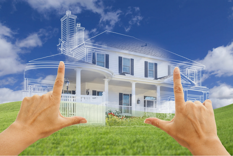 Hands framing a blueprint overlay on a house in a green field against a blue sky.