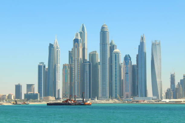 Dubai skyline with tall modern skyscrapers and construction activity, illustrating property development and investment.